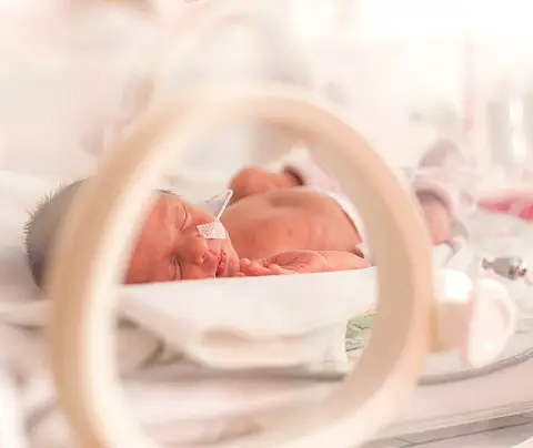 A closeup of a baby girl in a neonatal intensive care unit.