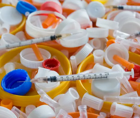 A collection of hypodermic needles and other medical supplies