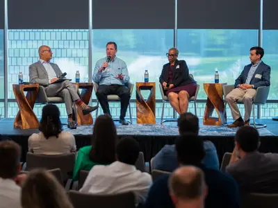 Photo of four panelists at RTI on stage having a discussion
