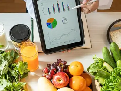 Nutrition graphs on an iPad with various healthy foods in the background