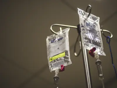 Two IV bags handing from metal pole. 