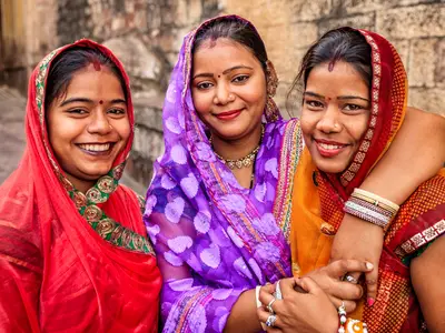 Photo of three young Indian women smiling outside