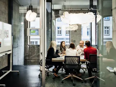 Group of business people sitting around a desk.