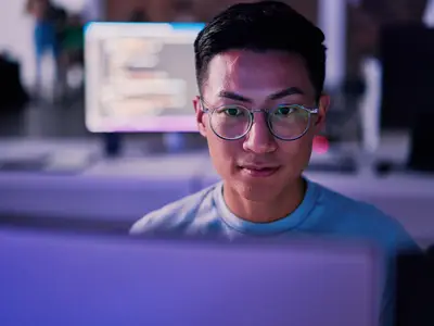 Male coder looking at code on computer