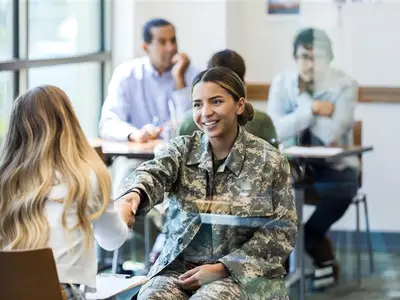 Woman in military uniform shaking another woman's hand