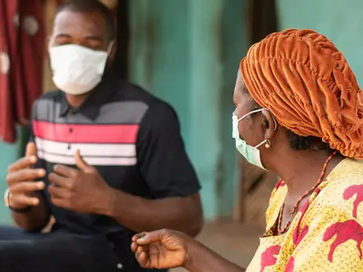 Two people with masks having a conversation