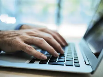 hands typing on keyboard of laptop