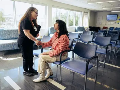 Provider meeting with patient in a lobby. The two are shaking hands