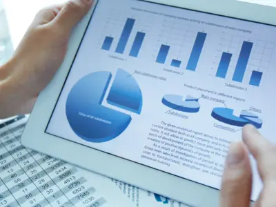 Person holding iPad with statistics on the screen