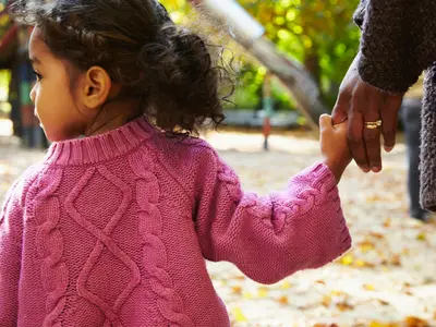 Child holding hands with parent