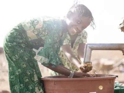 Girl washes hands under faucet