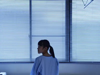 teen sitting on hospital bed in ward