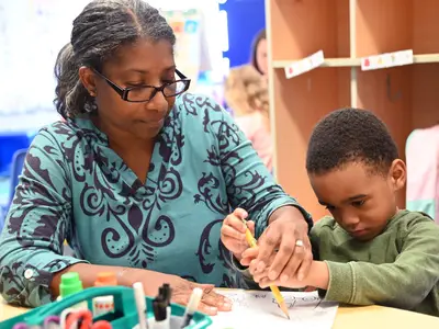 female educator helping elementary student