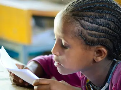 An Ethiopian girl reads from a paper in her classroom.