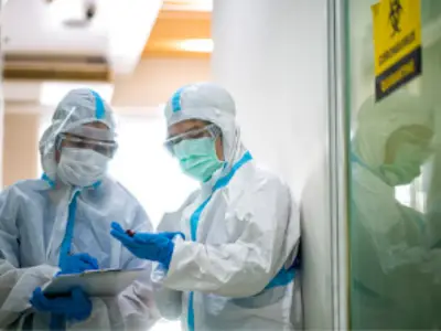 Two doctors wearing PPE looking at a chart together
