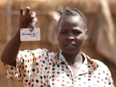 Bersila Fancis holds up her food ration card at a refugee camp in Ethiopia.