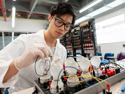 A high school student works in an electronics lab.