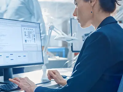 A researcher works on coding data at her computer.