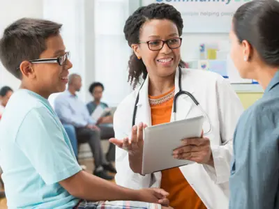 Doctor talking with a mother and child at community health clinic