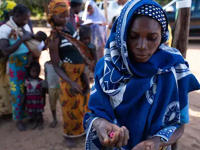 A woman holds pills being distributed as part of the effort to eliminate neglected tropical diseases in Mozambique.