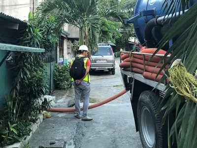 A sanitation worker services a building in Manila, Philippines.