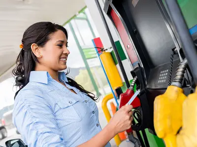 Woman pays for gas at pumps