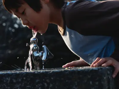 Child drinks from water fountain