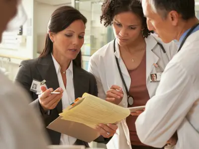 A team of doctors and nurses discuss patient care
