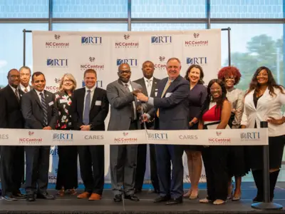 A group of people participate in a ribbon-cutting ceremony for NC Central University.