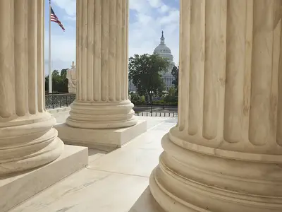 A view of the U.S. Capitol as seen from the columns of the Supreme Court building.