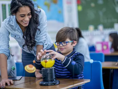 Male student getting help from female teacher