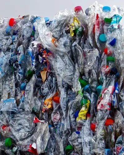 A large cube of plastic bottles, compacted for disposal.