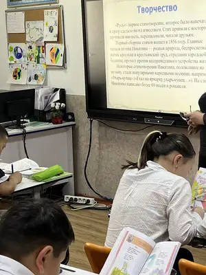 Students take notes while listening to a teacher in the Kyrgyz Republic.