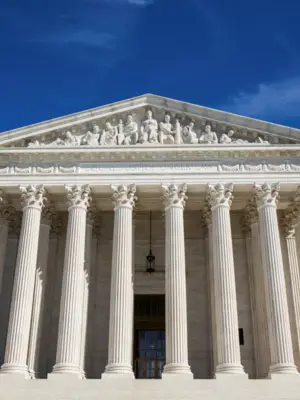 Photo of the United States Supreme Court building with blue sky in the background