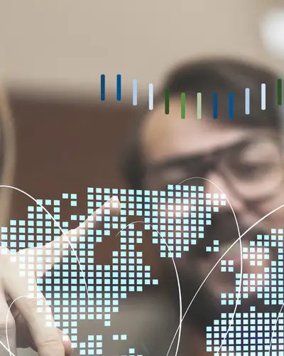 A woman and a man inspect a digital world map.