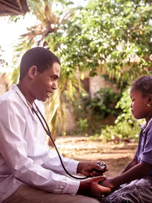 Photo of a doctor taking the pulse of a child