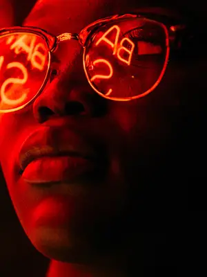 Person with glasses looking at an illuminated sign