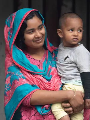 Photo of a Bangladeshi mother holding her child and smiling