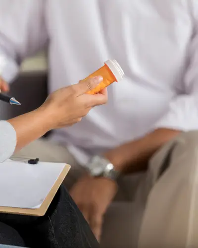 Photo of provider handing patient a bottle of pills.