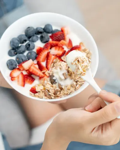 A bowl of yogurt with fruit and granola toppings