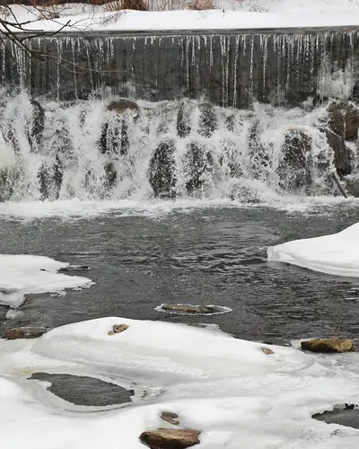 snow in river with waterfall