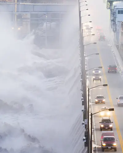 Cars going over bridge that's flooding