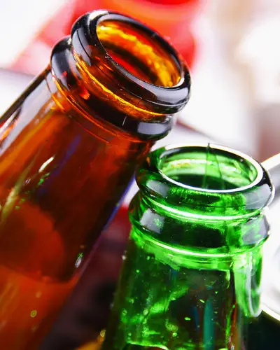 Closeup of glass bottles, aluminum cans, and other recyclable materials.