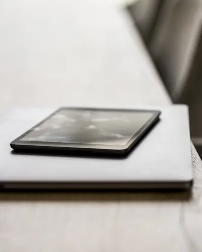 A laptop and a tablet sitting on a table
