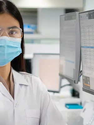 Female scientist in a laboratory looking at computer screens