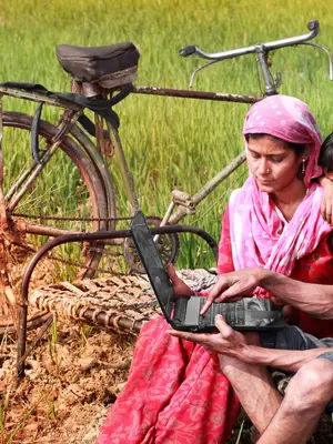 A family uses a laptop in a field