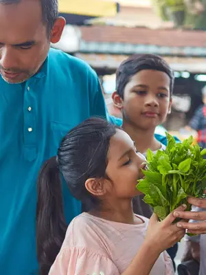 A family buying vegetables at an outdoor market