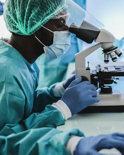 Scientists wearing protective gear study microbes.