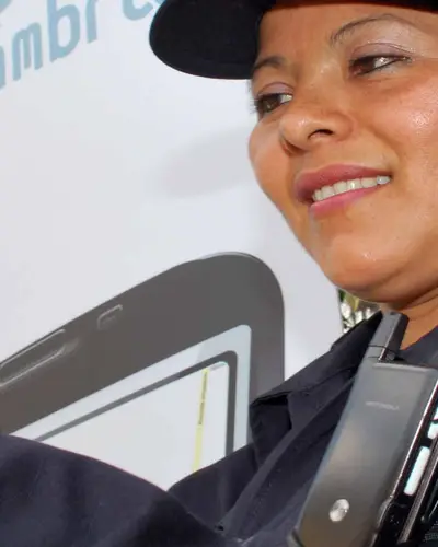 A Salvadoran law enforcement officer uses a mobile phone to report an incident