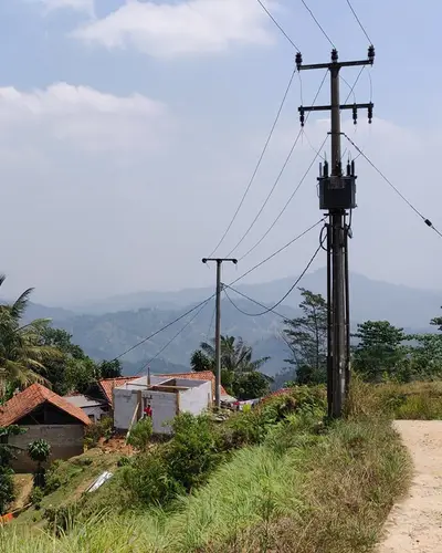 A power line runs along a dirt road in Sumba Island, Indonesia.